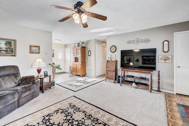 living room with ceiling fan, parquet floors, and a textured ceiling