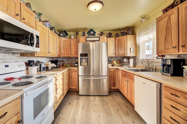 kitchen with tasteful backsplash, sink, white appliances, and light hardwood / wood-style flooring