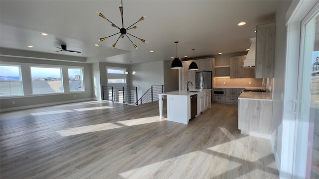 7018 Max Dr, Missoula, MT 59803 - kitchen with an island with sink, light countertops, dishwashing machine, light wood-style flooring, and open floor plan