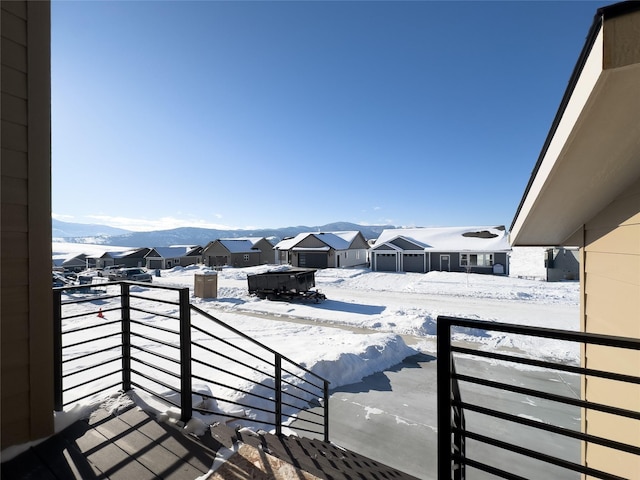 snow covered back of property with a mountain view