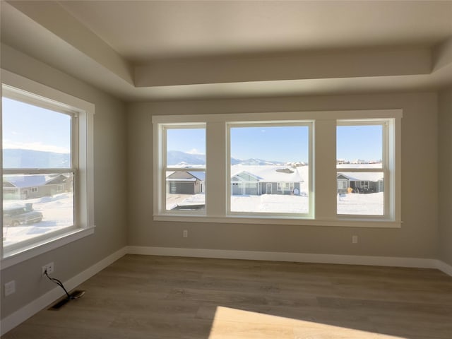 unfurnished room with a mountain view and dark hardwood / wood-style floors