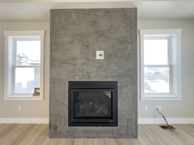 7018 Max Dr, Missoula, MT 59803 - interior details featuring baseboards, a glass covered fireplace, wood finished floors, and visible vents