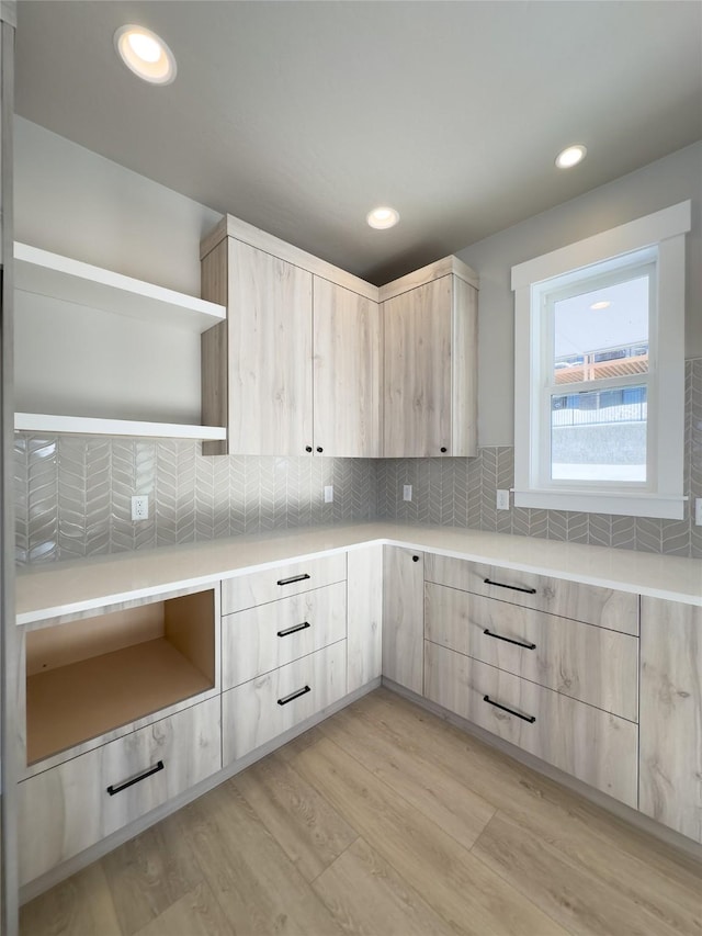 kitchen featuring light hardwood / wood-style flooring, decorative backsplash, and light brown cabinets