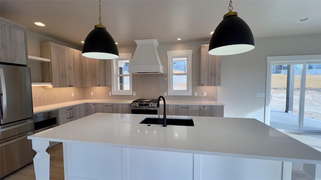 7018 Max Dr, Missoula, MT 59803 - kitchen with a sink, custom exhaust hood, modern cabinets, light countertops, and appliances with stainless steel finishes