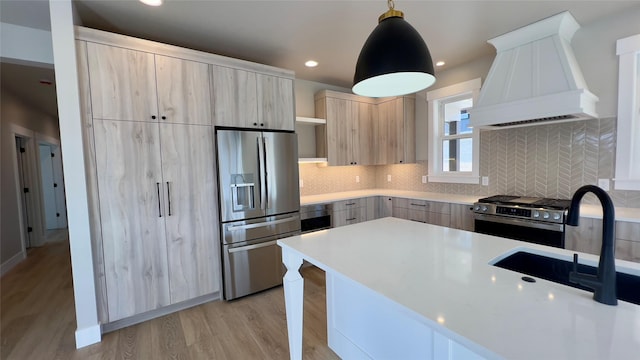 7018 Max Dr, Missoula, MT 59803 - kitchen with a sink, custom exhaust hood, modern cabinets, light brown cabinets, and appliances with stainless steel finishes