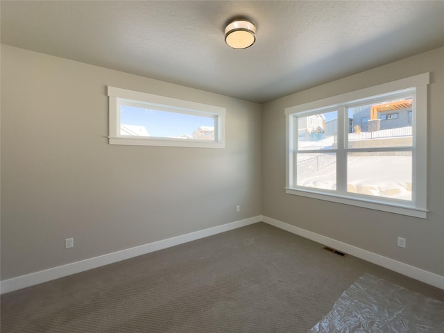 carpeted empty room with a textured ceiling