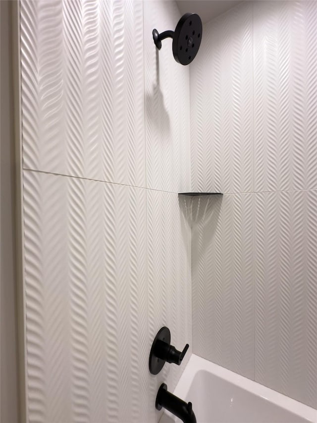 interior details with tiled shower / bath combo