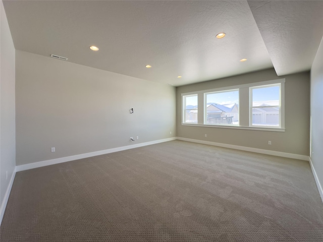 carpeted spare room with a textured ceiling