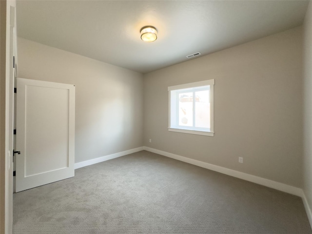 spare room featuring light carpet