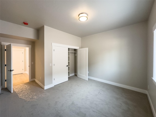 unfurnished bedroom featuring light carpet and a closet