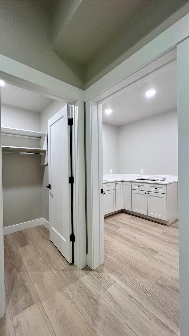 corridor with light hardwood / wood-style floors