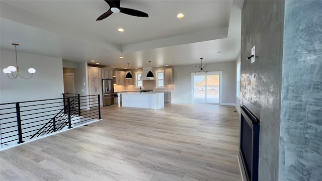 7018 Max Dr, Missoula, MT 59803 - unfurnished living room with ceiling fan with notable chandelier, baseboards, light wood finished floors, and recessed lighting