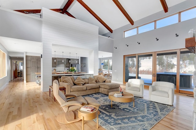 living room featuring beamed ceiling, high vaulted ceiling, and light wood-type flooring