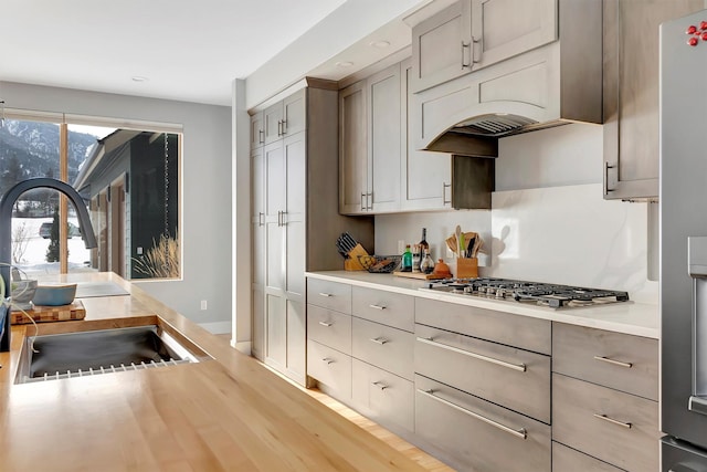 kitchen featuring appliances with stainless steel finishes, sink, and gray cabinetry