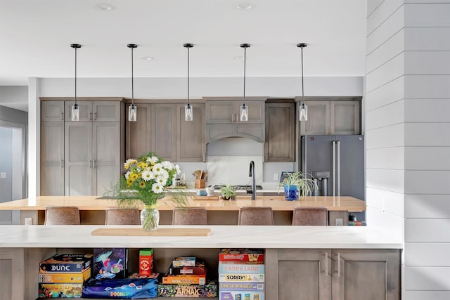 kitchen featuring stainless steel appliances, light stone countertops, and pendant lighting