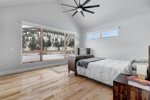 bedroom with ceiling fan, high vaulted ceiling, and light hardwood / wood-style flooring