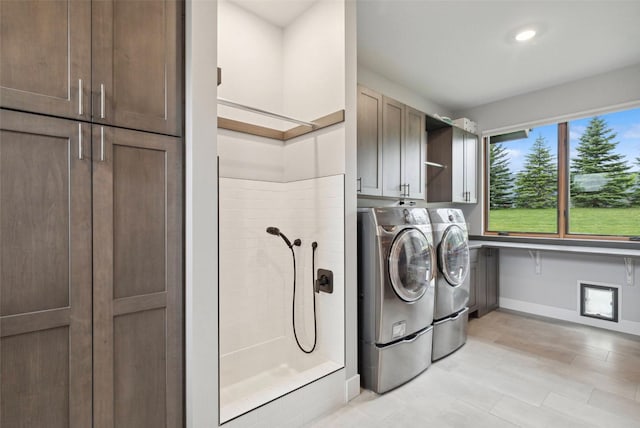 clothes washing area featuring cabinets and independent washer and dryer