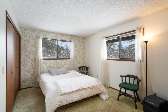 bedroom featuring carpet flooring, a textured ceiling, and wallpapered walls