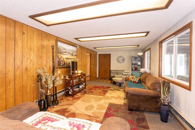 living room featuring a baseboard heating unit, carpet floors, a textured ceiling, and wooden walls