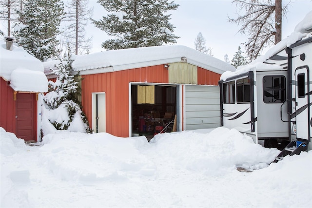 snow covered structure featuring an outbuilding and a pole building