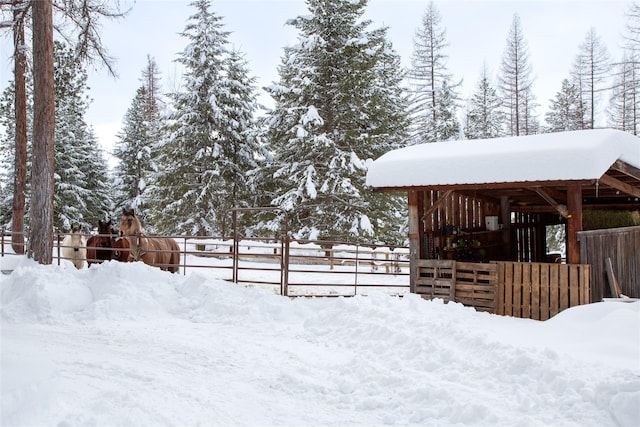 yard layered in snow featuring an exterior structure and an outdoor structure