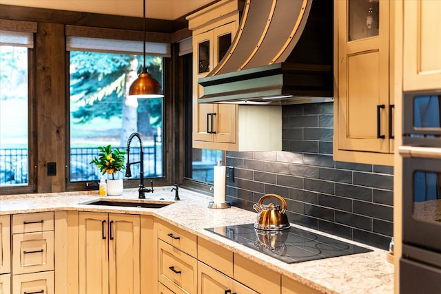 113 Levi Ct, Bigfork, MT 59911 - kitchen featuring black appliances, ventilation hood, tasteful backsplash, hanging light fixtures, and light stone counters
