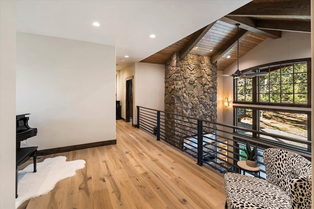 hall with high vaulted ceiling, light hardwood / wood-style flooring, wooden ceiling, and beamed ceiling