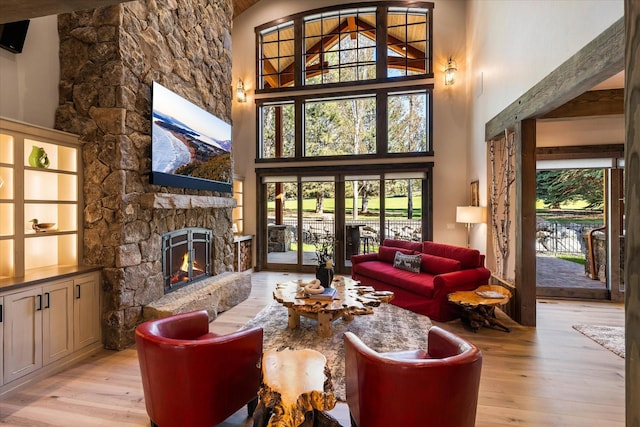 113 Levi Ct, Bigfork, MT 59911 - living room featuring light wood-style flooring, a fireplace, and a towering ceiling