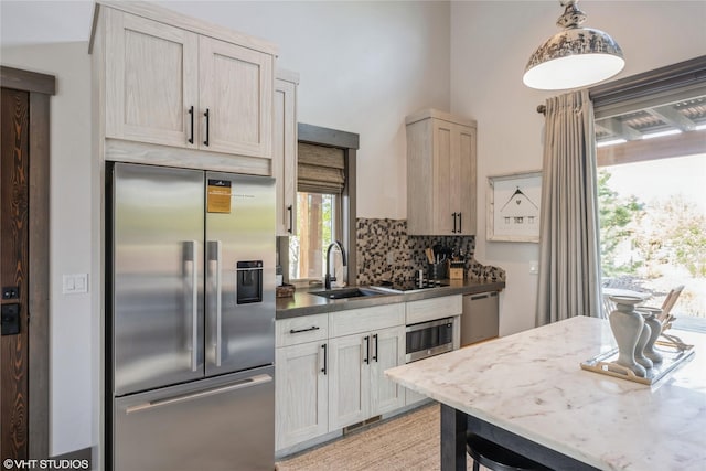76 Rusty Iron Way, Eureka, MT 59917 - kitchen featuring stainless steel appliances, a sink, backsplash, and decorative light fixtures