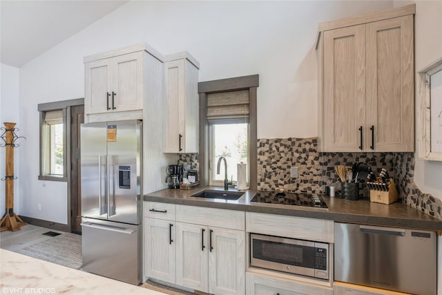 76 Rusty Iron Way, Eureka, MT 59917 - kitchen with appliances with stainless steel finishes, a sink, backsplash, lofted ceiling, and dark countertops