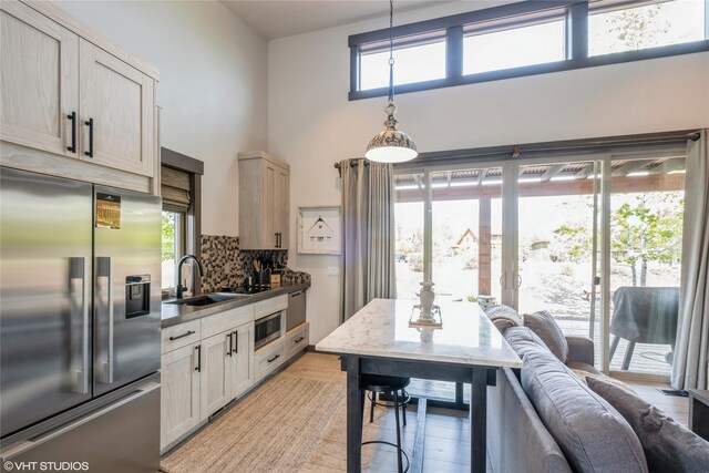 76 Rusty Iron Way, Eureka, MT 59917 - kitchen featuring stainless steel appliances, a sink, tasteful backsplash, light wood-style floors, and hanging light fixtures
