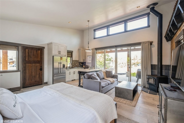76 Rusty Iron Way, Eureka, MT 59917 - bedroom featuring built in refrigerator, a towering ceiling, access to outside, a wood stove, and a sink