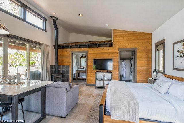 76 Rusty Iron Way, Eureka, MT 59917 - bedroom featuring a wood stove, wood walls, light wood finished floors, access to outside, and high vaulted ceiling