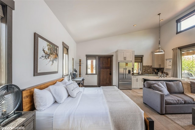 76 Rusty Iron Way, Eureka, MT 59917 - bedroom featuring stainless steel built in fridge, light wood finished floors, multiple windows, a sink, and high vaulted ceiling