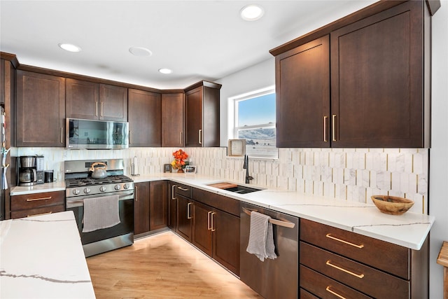 kitchen featuring stainless steel appliances, light stone countertops, and backsplash