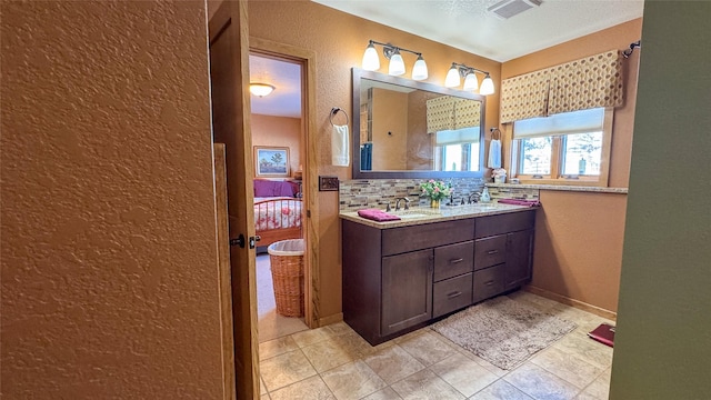 bathroom featuring vanity and backsplash