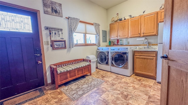 clothes washing area with cabinets, sink, and washer and clothes dryer