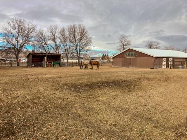 view of yard featuring an outdoor structure and a rural view