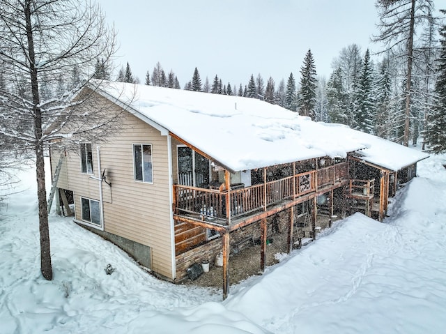 snow covered property with a wooden deck