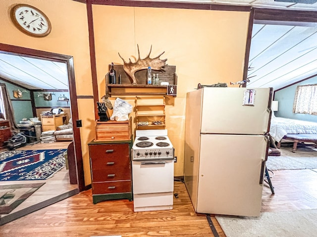 kitchen featuring lofted ceiling, white appliances, and light hardwood / wood-style floors