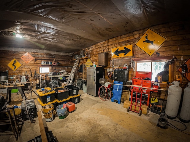 interior space with stainless steel fridge and a workshop area