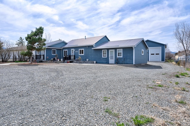 view of front of home with driveway, a garage, and metal roof