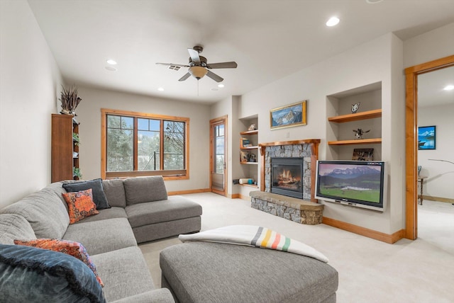 living room with light carpet, baseboards, built in features, a stone fireplace, and recessed lighting