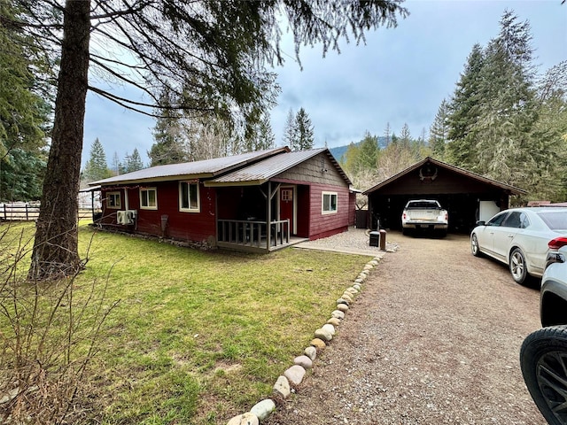 view of side of home featuring a lawn and a carport