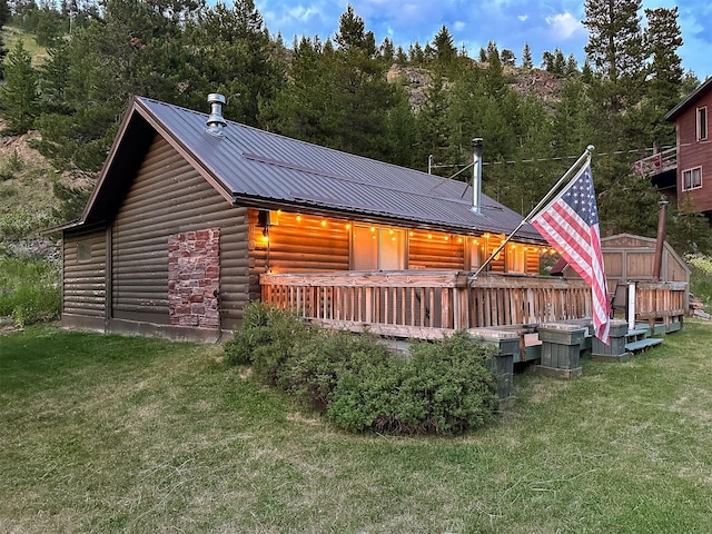 rear view of property featuring a yard and a deck