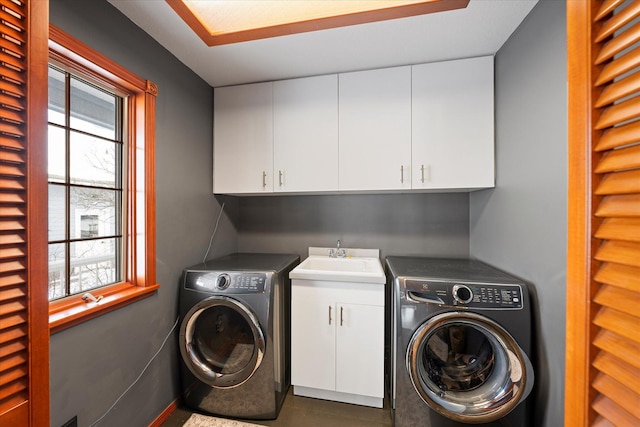 laundry room featuring separate washer and dryer, cabinet space, and a sink