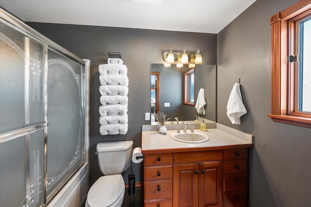 bathroom with toilet, shower / bath combination with glass door, and vanity