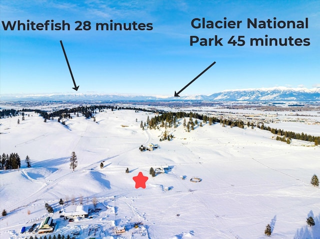 snowy aerial view featuring a mountain view