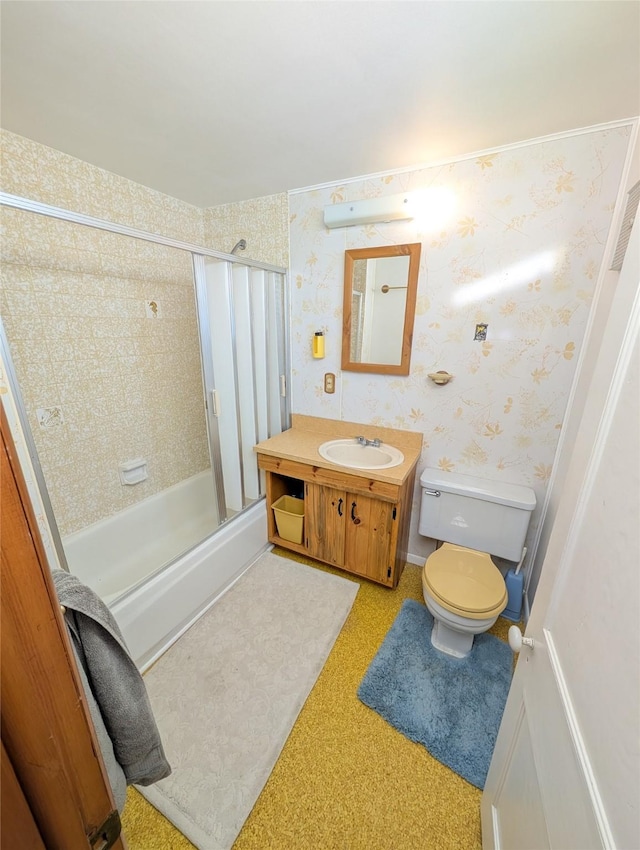 full bathroom featuring enclosed tub / shower combo, vanity, and toilet