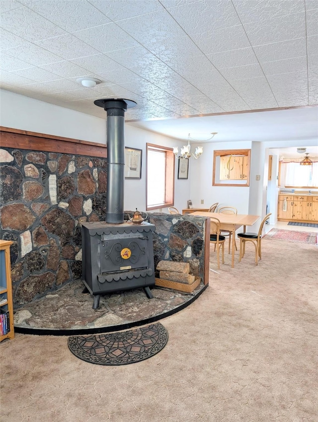 carpeted living room with a wood stove and a wealth of natural light